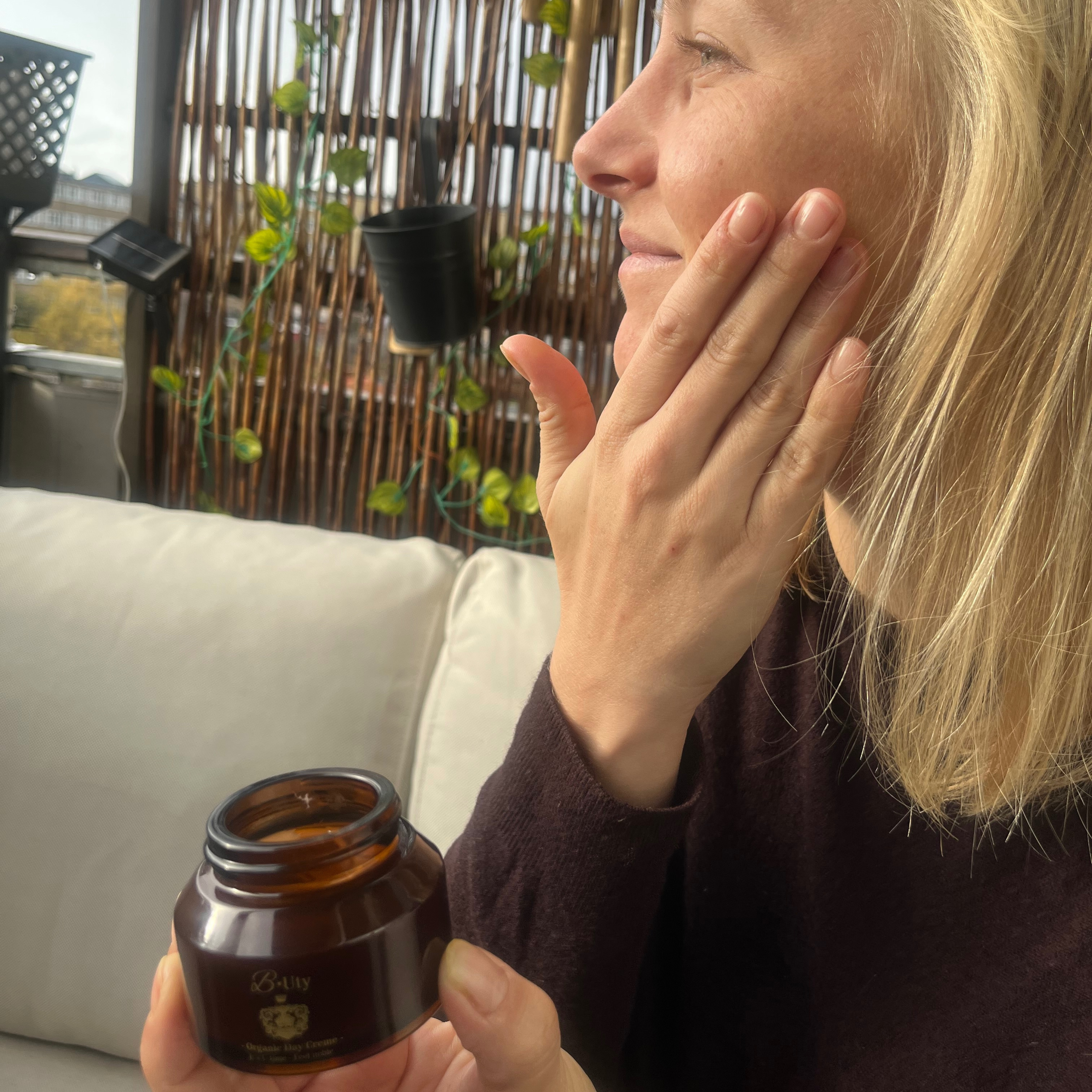 økologisk ansigtscreme fra B Uty med model som smører den i ansigtet